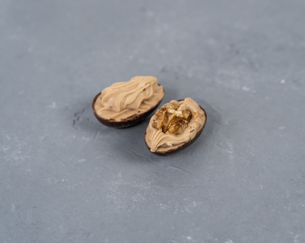 10 Nougat-Eier mit Walnuss in Bitterschokolade, gespritzt