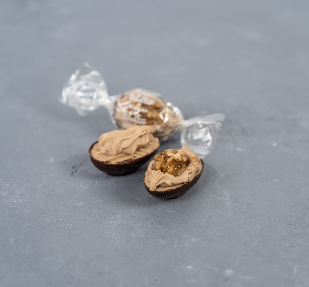 10 Nougat-Eier mit Walnuss in Bitterschokolade, gespritzt